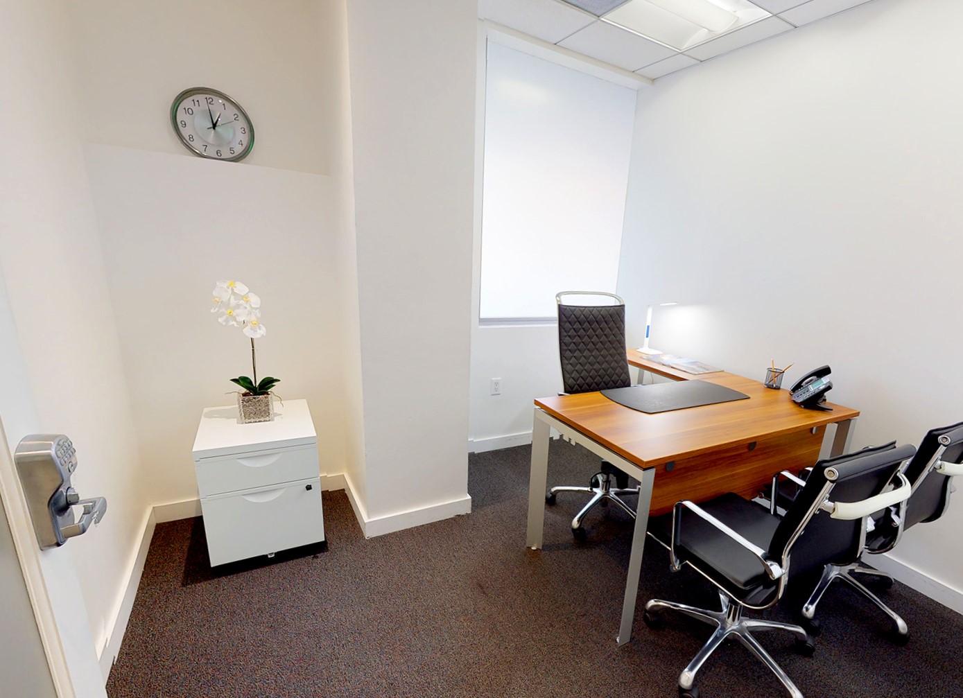 Compact private office with wooden desk, chairs and filing cabinet