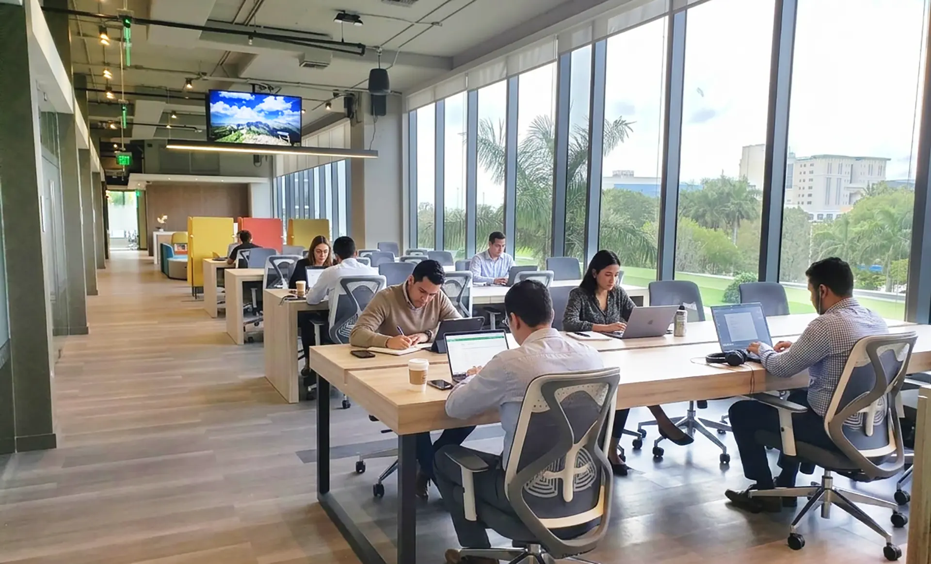 Coworkers at long shared tables in a coworking space