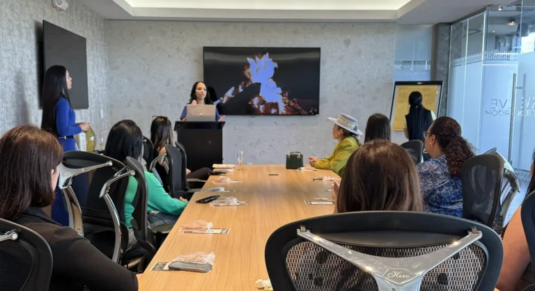 Speaker presenting to attendees around a conference table in a meeting room