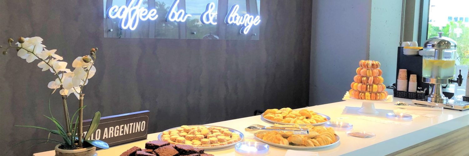 Coffee bar with pastries and neon sign at an Iconic Workspaces event