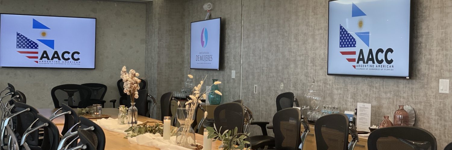 Meeting room set up for an AACC event with wall-mounted screens