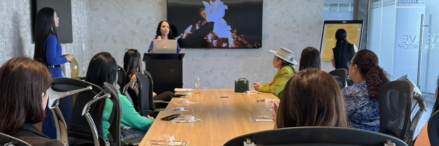 Speaker presenting to attendees around a conference table in a meeting room